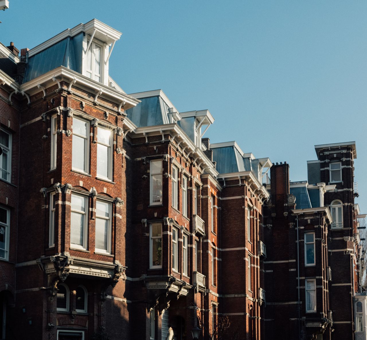 Mastering the First Impression: Your intriguing post title goes here Charming historic buildings showcasing Amsterdam's classic urban architecture under clear skies.