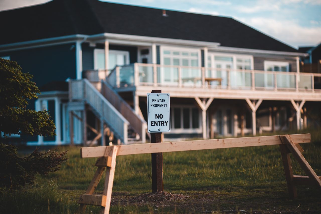 Sign indicating private property and no entry in front of modern house.